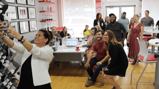 The Red Caffeine team in their office smiling and taking a group selfie
