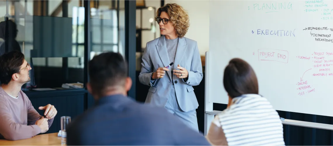 Women Stanfding and giving presentation on white board