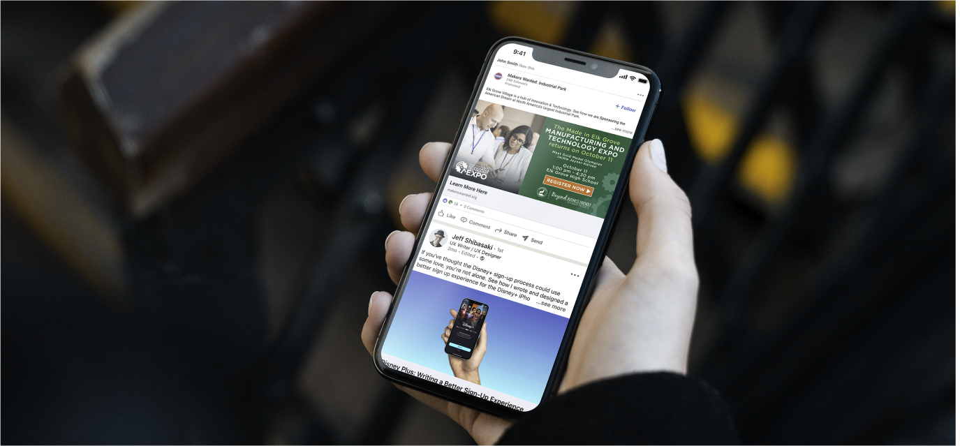 Hand holding a phone that shows Facebook ads