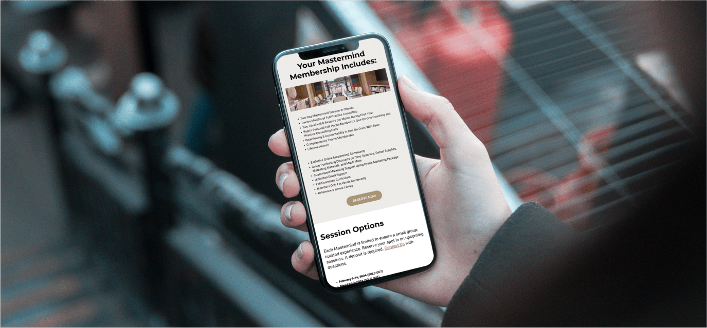 Hand holding a phone that shows a website listing Mastermind membership options