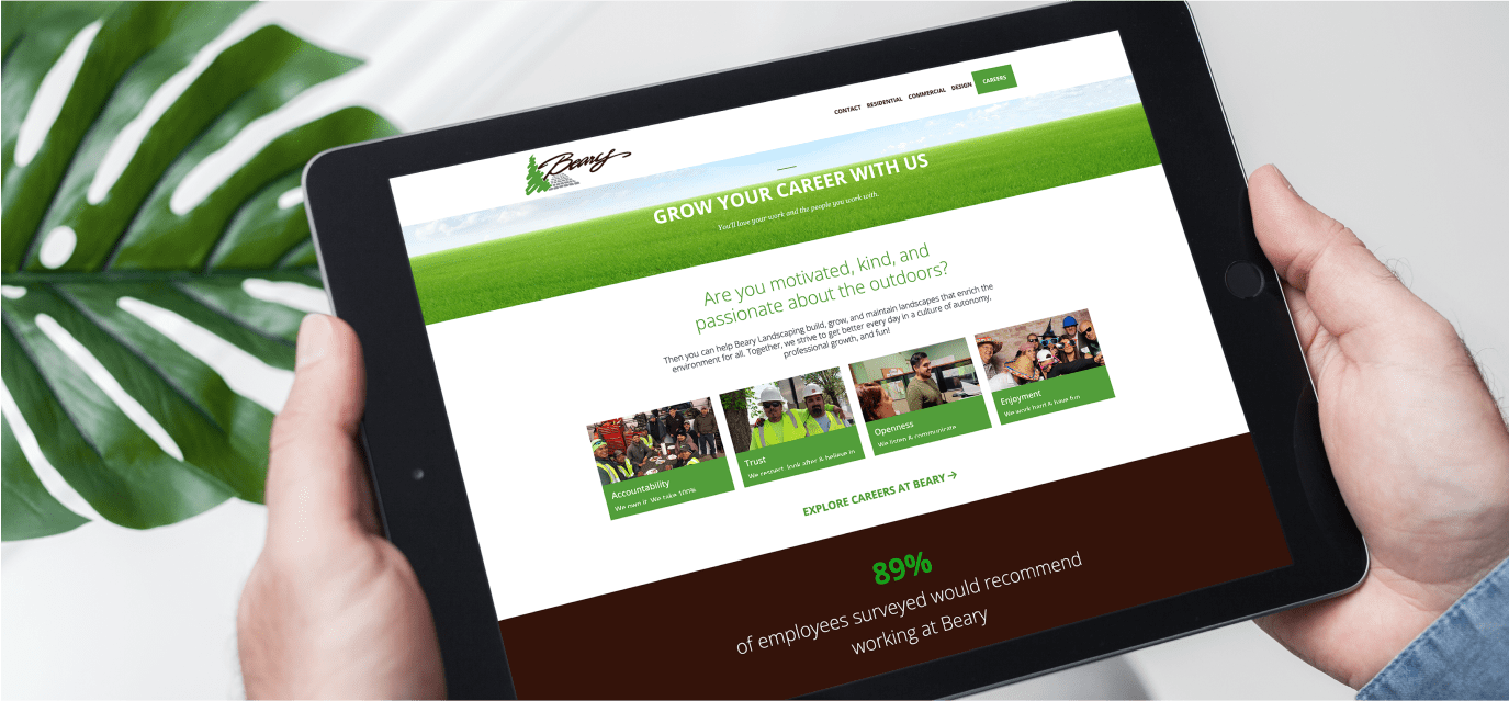 Hands holding a tablet showing a green career website