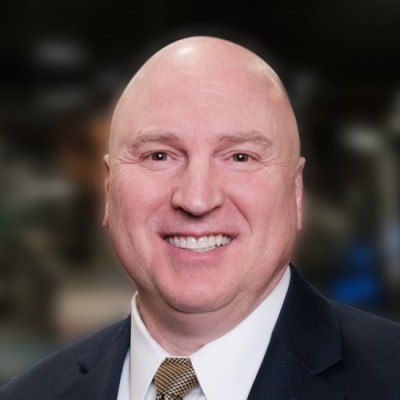 Bald man in a business suit, smiling